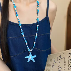 Dettaglio della collana di perle con ciondolo a stella marina blu per stile da spiaggia
