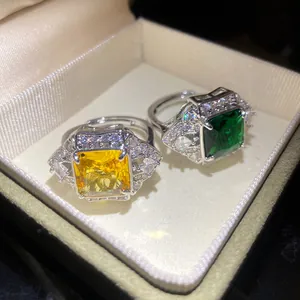 Detailed view of yellow and green square zircon rings in a beige velvet jewelry box