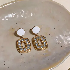 Detailed view of French retro gold-toned square drop earrings with sparkling rhinestones