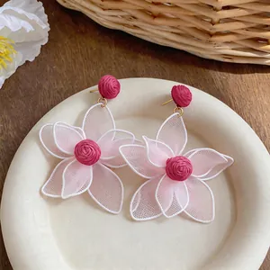 Detailed close-up view of bohemian mesh flower earrings with magenta rose accents