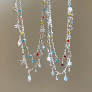 Macro view of double-layered silver necklace featuring starfish charms and colorful stones