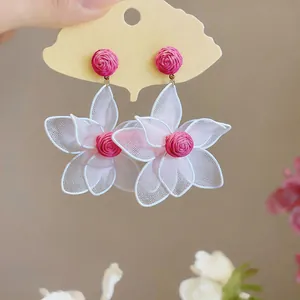 Detailed view of bohemian floral drop earrings with pink rose studs and white mesh petals