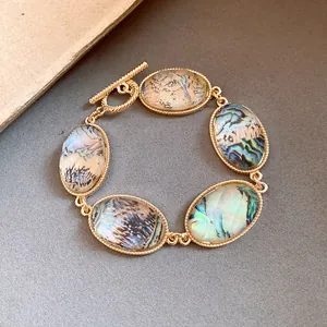 Detail view of a vintage gold OT bracelet with iridescent faceted oval resin stones