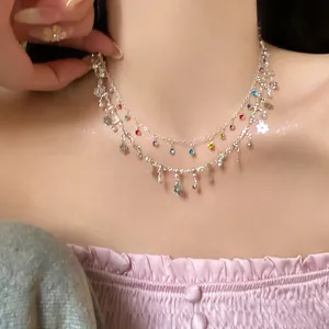 Detail view of a double-layered silver necklace with colorful rhinestones and flower charms