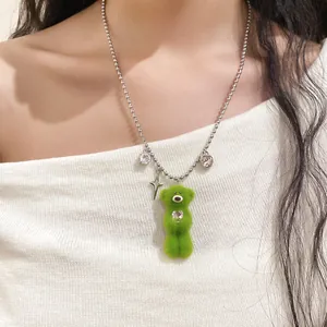 Close-up of cute green flocked bear necklace with heart and star charms on model neck