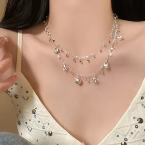 Detailed view of a double-layer necklace with shell and starfish charms on a model.