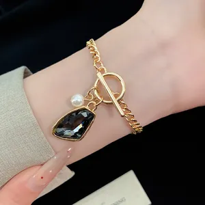 Detail of retro gold chain bracelet with irregular dark crystal and pearl