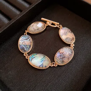 Detail of iridescent oval resin stones and gold toggle clasp on a retro bracelet.