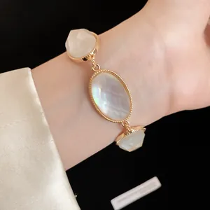 Close-up of faceted resin oval stones on a gold OT chain bracelet.