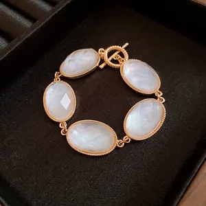 Detailed macro view of an elegant gold OT chain bracelet featuring five oval faceted resin stones.