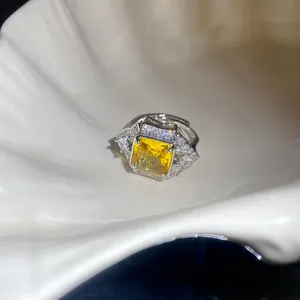 Detailed view of elegant square yellow zircon adjustable ring in white seashell prop
