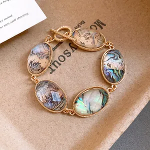 Close-up of French retro gold bracelet with faceted oval abalone resin stones.