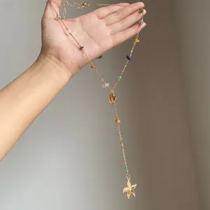 Dettaglio della collana di perline fatta a mano con ciondoli a conchiglia e stella