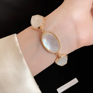 Detail shot of a vintage gold bracelet featuring three white faceted resin stones