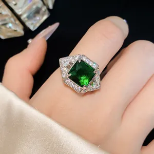 Close-up of a luxury square emerald green zircon ring on a finger with satin sleeve