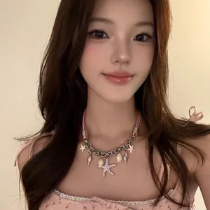 Gros plan d'un collier en cuir rose avec étoile de mer et coquillage porté par un mannequin.