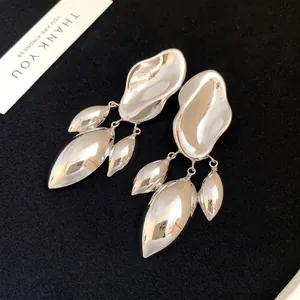 Irregular geometric shiny silver drop earrings with a minimalist twisted design.