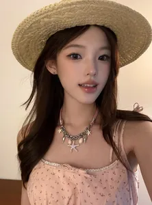 Gros plan d'un collier en cuir avec étoile de mer et coquillages porté par un mannequin