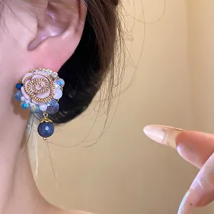 Macro view of vintage-inspired resin flower earrings with elegant blue bead details