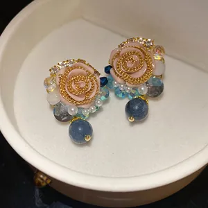 Detailed view of French retro resin rose earrings with pearls and blue crystal beads