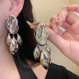 Close-up of silver needle irregular geometric glossy distorted pendant earrings for women