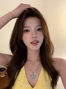 Gros plan d'un collier étoile de mer délicat avec breloque coquillage porté par un mannequin