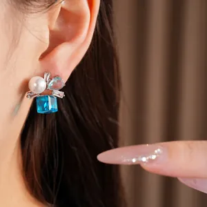 Detaillierte Nahaufnahme von luxuriösen Silberohrringen mit blauem Zirkonia und Perle