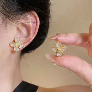 Nahaufnahme exquisiter 18 Karat vergoldeter Blumenohrstecker mit funkelnden Zirkonen.