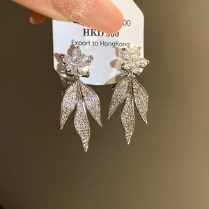 Close-up of elegant flower and sparkling leaf earrings with 14k gold plating