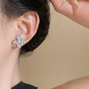 Nahaufnahme von exquisiten 18k Silbernadel-Blumen-Zirkonia-Ohrsteckern am Ohr