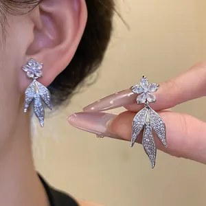 Macro view of 14k gold plated zircon flower and leaf tassel earrings detailing