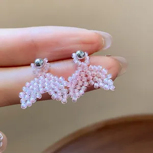 Detailed close-up of pink seed bead fishtail stud earrings with silver needles design