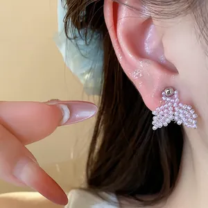 Close-up detail of elegant purple beaded fishtail stud earrings on ear