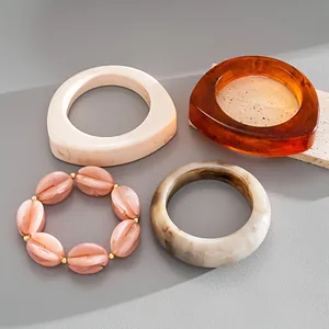 Vintage Armreif- und Perlenarmband-Set aus Acrylharz mit Marmorierungsmuster.