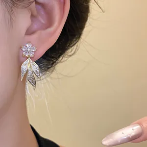 Detailed view of elegant 14k gold plated flower tassel earrings with zircons on ear