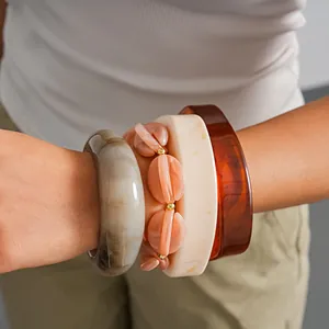 Detailansicht geschichteter Vintage Marmor-Acryl-Armreifen und elastischer Perlenarmbänder.