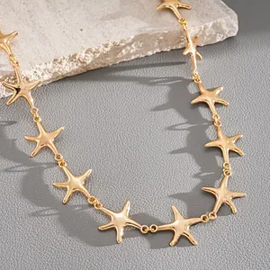 Detailed close-up of golden metal starfish links on a minimalist choker necklace.