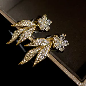Close-up detail of luxurious 14k gold plated flower earrings with sparkling zirconia stones