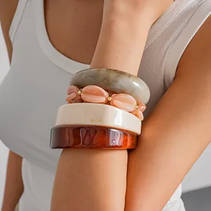 Detailansicht von Vintage-Armreifen aus marmoriertem Acryl am Arm eines Models getragen