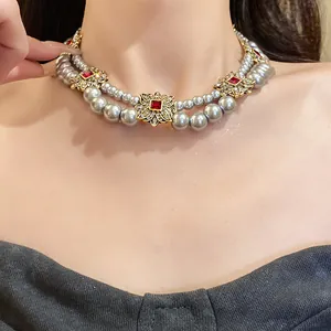 Detailed view of an elegant double-row pearl necklace with vintage gold floral accents