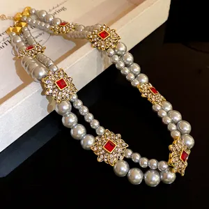 Detail of French retro double-row pearl necklace with gold flower ornaments and red gems