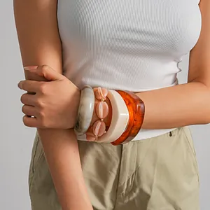 Detailansicht eines Modells mit Vintage-Acrylreifen und elastischen Perlenarmbändern im Set