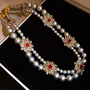 Detailed view of French vintage double-strand pearl necklace with red crystal accents