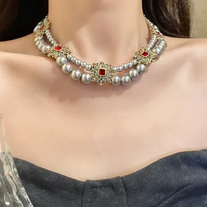Elegant French vintage double-strand grey pearl necklace with red stones on a model's neck