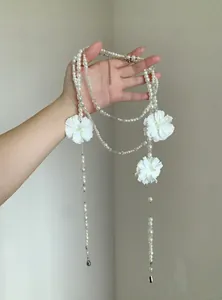 Vista dettagliata di elegante collana di perle a più strati con fiori di camelia