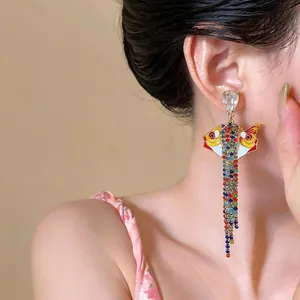 Boucles d'oreilles poisson avec glands colorés, huile égouttée, strass et tige en argent.