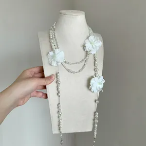 Vista dettagliata di una collana di perle a più strati con fiori di camelia