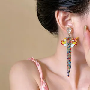 Boucles d'oreilles pendantes en forme de poisson avec strass colorés sur mannequin