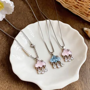 Close-up of glass cloud pendants with zircon teardrops on a white shell plate.
