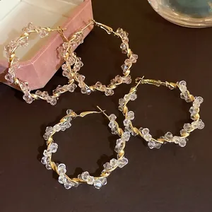 Elegant gold twisted hoop earrings featuring clear crystal bead embellishments for women